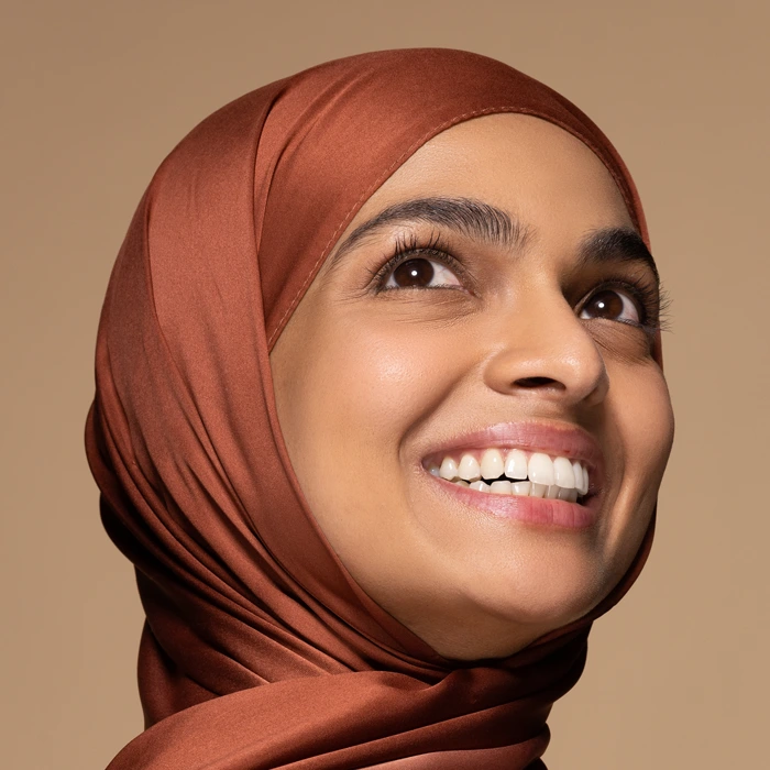 portrait of beautiful south Asian woman in her 20s wearing a hijab posing confidently on neutral background