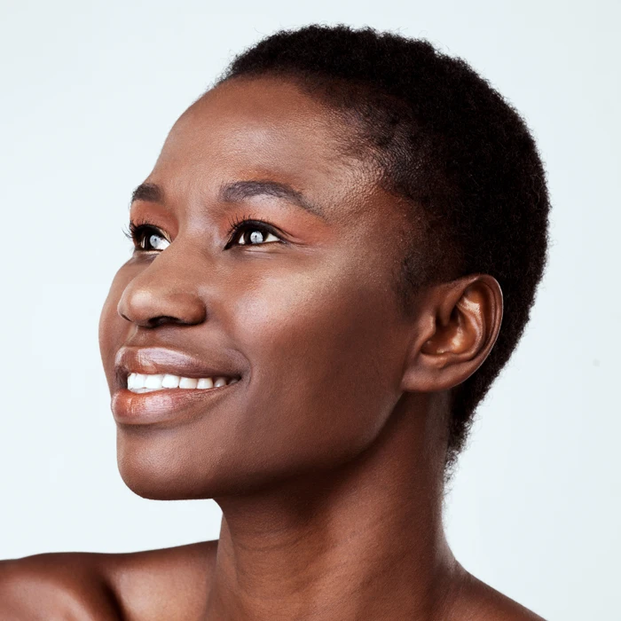 Studio shot of a beautiful young woman looking thoughtful against a grey background.