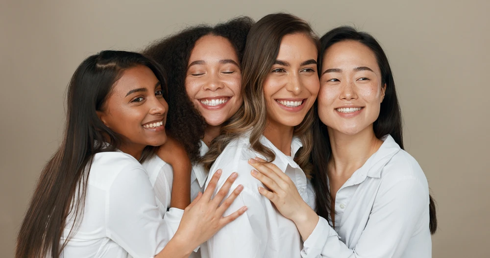 Women, group skincare and beauty with love, hug and support in diversity and inclusion on brown studio background