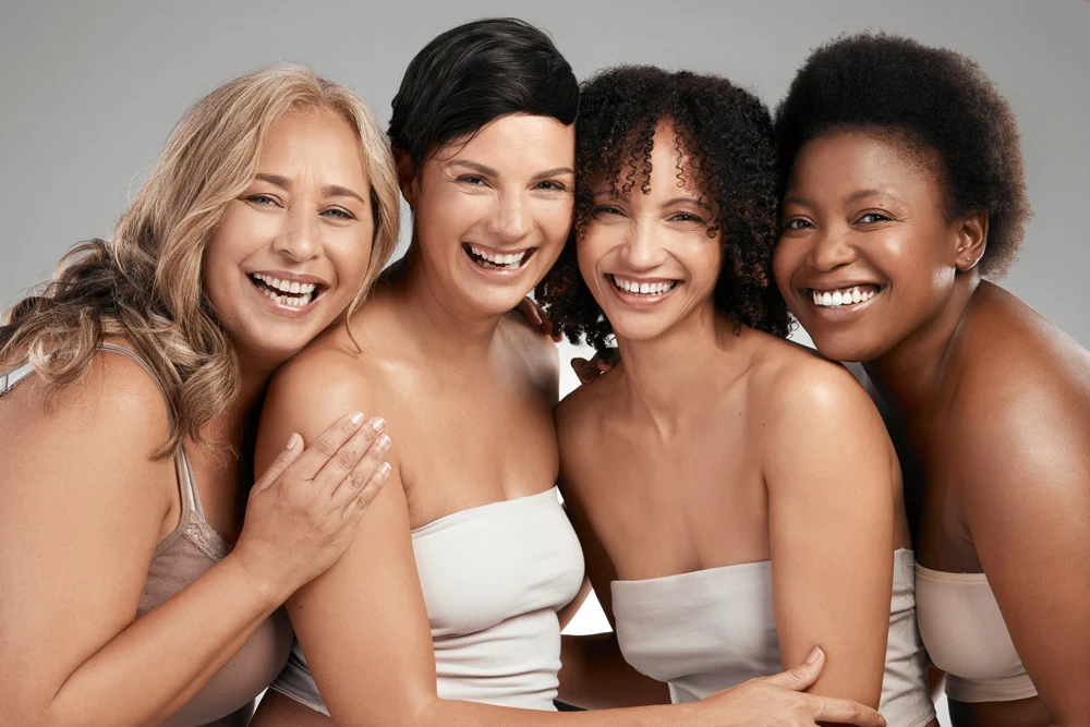 Shot of a diverse group of women standing and hugging each other in the studio