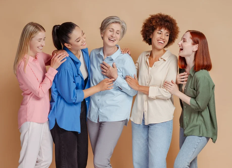 Group portrait of beautiful smiling multiracial women wearing stylish colorful t shirt talking